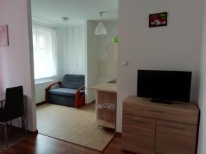 a living room with a television on a wooden dresser at Apartament u Magdy in Międzyzdroje