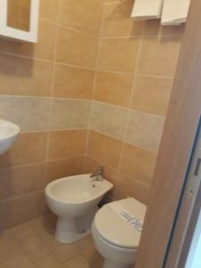 a bathroom with a toilet and a sink at Affittacamere FloraMare in Marina di Bibbona +14 photos