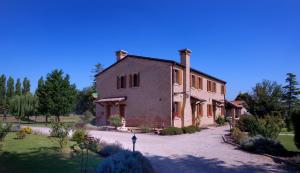 un antiguo edificio de ladrillo con una entrada delante de él en Il Dosso Agriturismo, en Codigoro