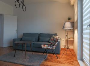 a living room with a blue couch and a table at Apartment Mihajlovic in Vranje