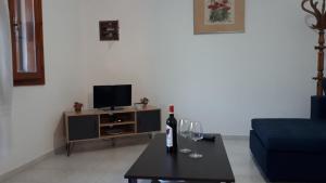 a living room with a bottle of wine on a table at Alexandra Apartments in Skala Fourkas