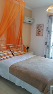 a bedroom with a large bed with an orange canopy at Christina Pansion in Kokkari