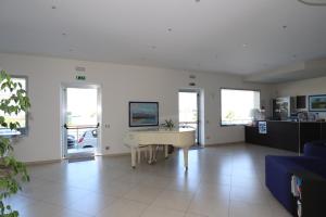 un soggiorno con un tavolo e un divano blu di Hotel Celeste a Marzamemi