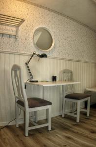 einen Schreibtisch und Stühle mit einer Lampe und einem Spiegel in der Unterkunft Lundsbrunn B&B in Lundsbrunn