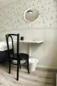 Lundsbrunn的住宿－Lundsbrunn B&B，一张黑椅子,坐在墙上的房间