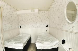 ein kleines Zimmer mit 2 Betten und einem Spiegel in der Unterkunft Lundsbrunn B&B in Lundsbrunn