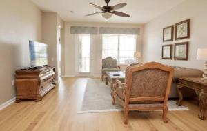 a living room with a couch and a table and a piano at Shoreway Condo #231522 in Orlando