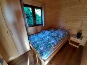a bedroom with a bed in a room with a window at Domki Letniskowe REKINEK in Darłowo