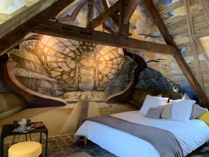 a bedroom with a bed with a painting on the wall at La Poupardoise in Honfleur