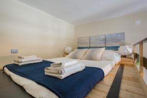 a bedroom with a large bed with towels on it at Kalea Apartment in Avola