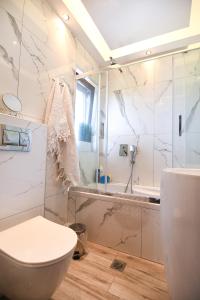 uma casa de banho com um WC, uma banheira e um lavatório. em THEASIS Luxury Panoramic Penthouse em Neos Marmaras