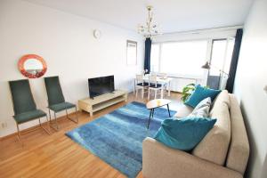 a living room with a couch and a blue rug at Stay Here Apartment Kamppi in Helsinki