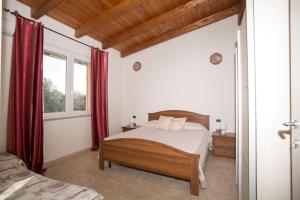 a bedroom with a bed and a window with red curtains at Casa vacanze "Gli Ulivi" Apt 1 in Matzaccara