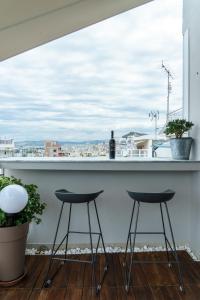 a balcony with two stools and a bar with a view at Small & cosy with Acropolis & Lycabettus view in Athens