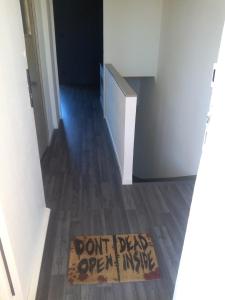 Una señal que dice que no se abra por dentro en una alfombra en el suelo. en Appartement en duplex au 3ième étage sans ascenseur, en Hyères