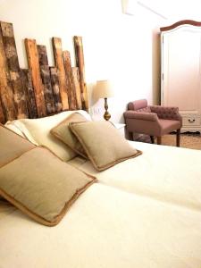 una camera da letto con letto, cuscini e sedia di Ceglie Antica a Ceglie Messapica
