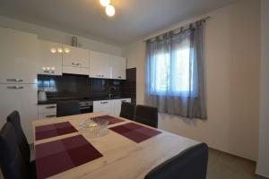 Una cocina con una mesa de madera y un comedor. en House Mia, en Starigrad-Paklenica