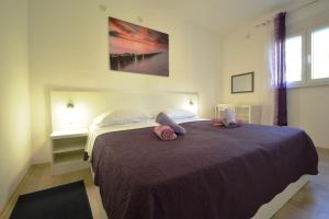 Un dormitorio con una cama grande con almohadas rosas. en House Mia, en Starigrad-Paklenica