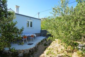 una casa con mesa y sillas en un jardín en House Mia, en Starigrad-Paklenica