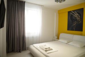 a bedroom with a white bed and a window at Milan in Mamaia Nord +22 photos