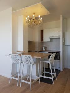 a kitchen with a table and chairs and a chandelier at L'Albâtre in Dieppe