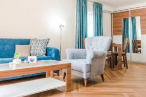 Apartments Stella del Mare في ريسان: غرفة معيشة مع أريكة زرقاء وكرسي