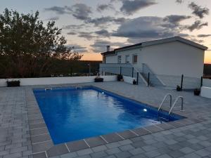 a swimming pool in front of a house at Apartman Nina in Kruševo