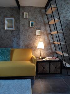 - un salon avec un canapé jaune et une échelle dans l'établissement 900 meters from Metro&Station CEVA STUDIO, à Turin