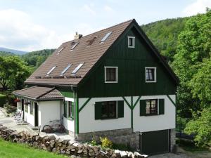 Casa verde y blanca con pared de piedra en U Górali en Jelenia Góra-Jagniątków