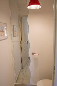 a bathroom with a toilet and a light on the wall at Petit nid douillet Décines in Décines-Charpieu