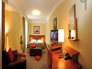 une chambre d'hôtel avec un lit et une télévision dans l'établissement Hotel Post, à Bad Gastein