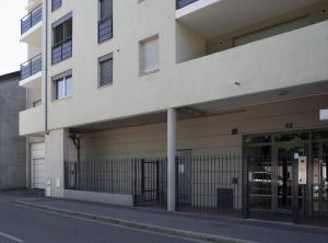 a white building with a gate in front of it at Petit nid douillet Décines in Décines-Charpieu