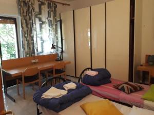 シエナにあるBed in Sienaのベッド2台、テーブル、デスクが備わる客室です。