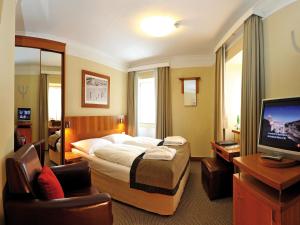 een hotelkamer met een bed en een televisie bij Hotel Post in Bad Gastein