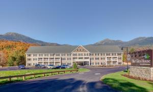 a large building on a street with mountains in the background at The Glen House in Gorham