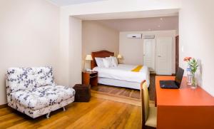 a bedroom with a bed and a chair and a desk at Alwa Hotel Boutique Premium in Arequipa