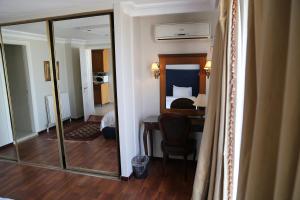 Habitación de hotel con espejo y dormitorio en Gondola Hotel & Suites, en Amán