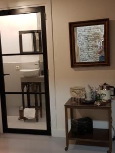 a bathroom with a mirror and a sink and a table at B&B The Project in Heerlen +31 photos