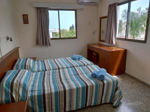 a bedroom with a bed and a dresser in it at Maricosta Apartments in Protaras +23 photos