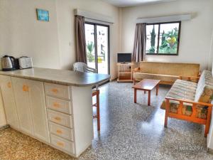 uma sala de estar com uma mesa e um sofá em Maricosta Apartments em Protaras