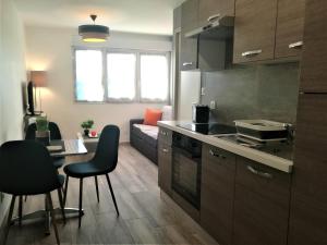 a kitchen and living room with a table and chairs at T2 Centre Ville Place Méditerranée in Perpignan