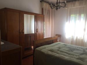 um quarto com uma cama, um armário e uma janela em Villa Romolina em Coreglia Antelminelli