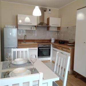 a kitchen with a table with two chairs and a table sidx sidx sidx at Słoneczny - Mala Apartamenty in Wejherowo