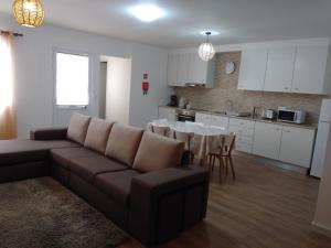 a living room with a couch and a table and a kitchen at Sweet Dreams near Beaches in Ponta Delgada