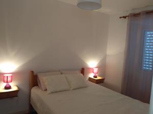 um quarto com uma cama e 2 candeeiros nas mesas em Sweet Dreams near Beaches em Ponta Delgada