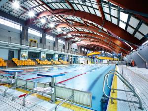 an empty swimming pool with yellow tables and chairs at Stadium Apart in Warsaw