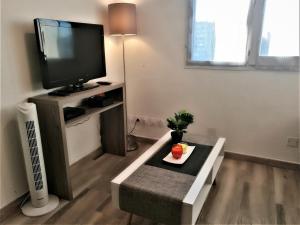 a living room with a flat screen tv and a table at T2 Centre Ville Place Méditerranée in Perpignan