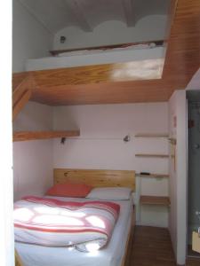 a bunk bed in a small room with wooden ceilings at Onkel Inn in La Paz