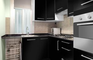 Una cocina con gabinetes negros y un fregadero. en Magic Apartment with Private Terrace, en Barcelona