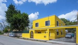 uma casa amarela ao lado de uma rua em Casa Flamingo em Valladolid
